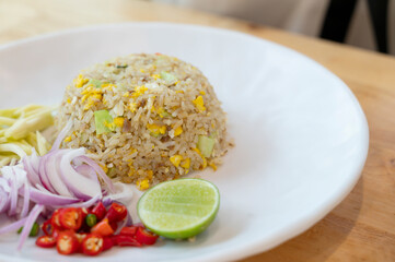 Prawn fried rice on white plate on wooden table background