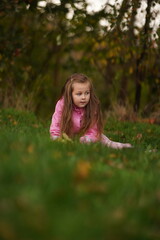 Portrait of a smiling little girl lying on green grass. Selective focus