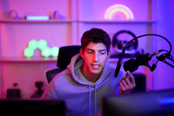 Caucasian streamer young man speak with podcast microphone while review and recommend game online...