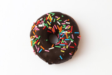 chocolate donut with multi-colored topping on a white background. top view