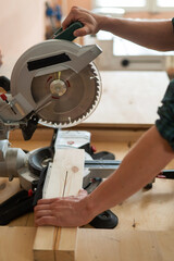 Master cuts the board with a circular saw in the workshop. 
