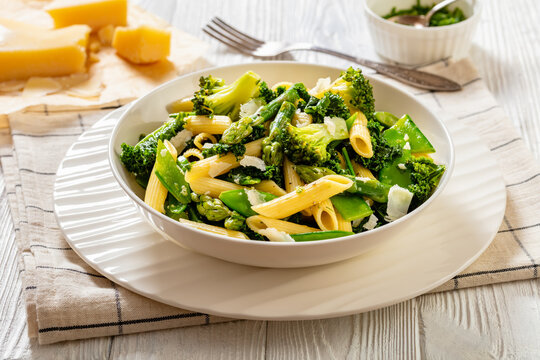 Pasta primavera with green veggies, cheese in bowl