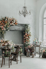 Stylish bright interior of the living room, decorated for Easter. Fireplace with flowers. There's no one in the room.