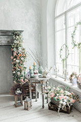 Stylish bright interior of the living room, decorated for Easter. Fireplace with flowers. There's no one in the room.