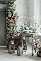 Stylish bright interior of the living room, decorated for Easter. Fireplace with flowers. There's no one in the room.