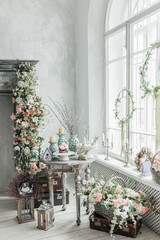 Stylish bright interior of the living room, decorated for Easter. Fireplace with flowers. There's no one in the room.