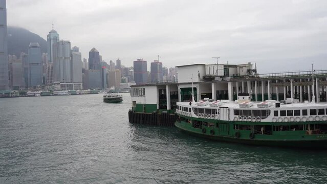 StarFerry pier in TsimShaTsui, Hong Kong. City skyline in the background on a cloudy day.