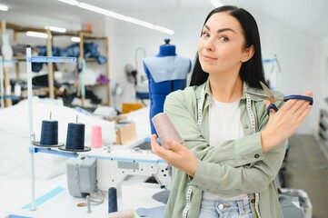 Seamstress at work. Dressmaker making clothes in modern studio.