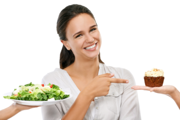 An attractive young diet-conscious female making an unhealthy decision by pointing and selecting chocolate, cupcake, or sugar-coated cake over healthy, green vegetables isolated on a PNG background. 