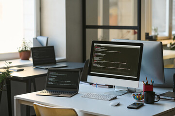 Modern workplace of programmer with computers on table in modern office