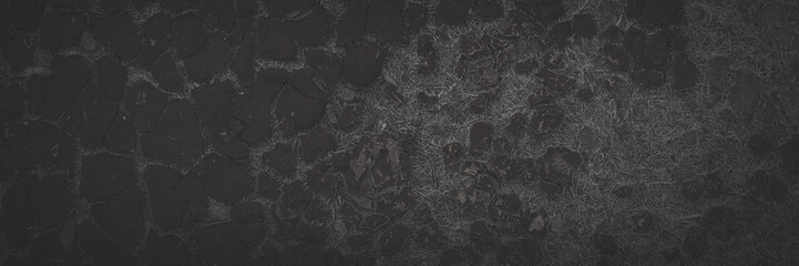 Texture of old cracked artificial leather. Faded dark wide panoramic background for design. The surface of the dried leatherette with lots of cracks and pieces of brown material. Faux leather texture.