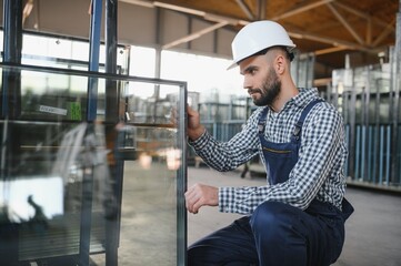 The glazier carries the glass in the glass factory.