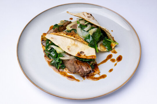 Potato pancakes with goose liver and steamed fresh spinach