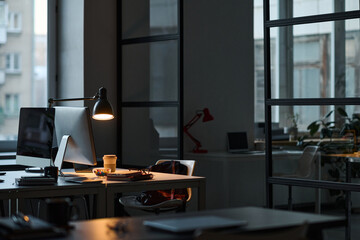 Horizontal image of workplace of developer with computer on table in dark IT office