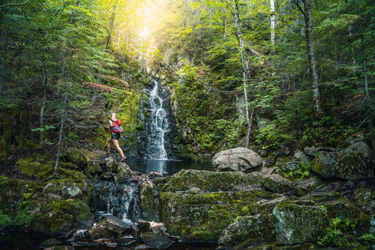 Hiker passing scenic waterfall, Quebec, Canada