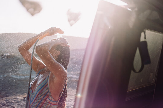 Girl takes shower out of her vintage camper van, Tenerife, Canary Islands, Spain