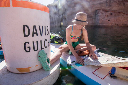 Paddleboarder checking map, Utah, USA