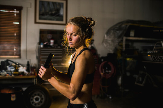 Woman lifting weights in garage