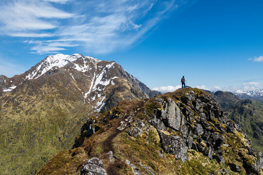 Female hiker on trail to Mannen with Himmeltindan in background, Vestv&Atilde;&yen;g&Atilde;&cedil;y, Lofoten Islands, Norway