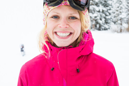Young woman with bright smile skiing in mountains