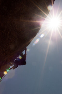 Silhouette of the climber on a difficult route with the sun behind him