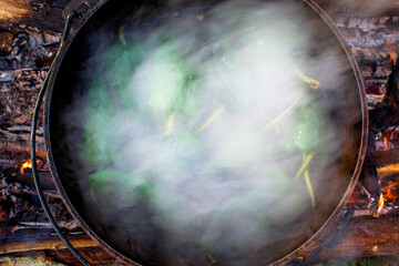 Atchafalaya River, Louisiana, USA. A steaming pot of poblano peppers cooked over a wood fire.