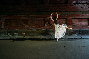 ballerina dancing under bridge outside