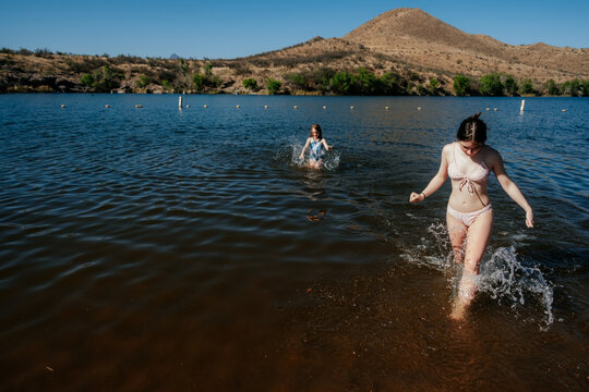 Siblings playing in a lake on a sunny day