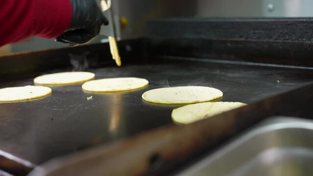 Stacking the soft shell corn tortillas on the flat top after grilling - food taco series