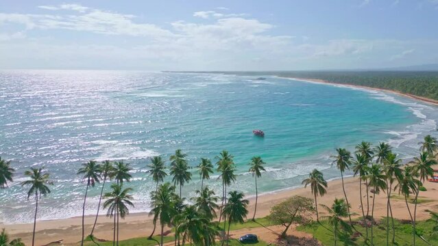 Reflections of sunlight on surface of waters of Los Coquitos beach, Cabrera in Dominican Republic. Aerial drone panoramic view