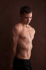 Fototapeta premium Handsome muscular shirtless adolescent boy flexing muscles.