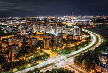 Fototapeta na wymiar Long exposure of blocks of flats at night with traffic trails and lights - modern Krakow cityscape