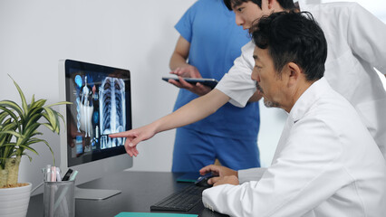 Fototapeta premium パソコンを見て会議する医療従事者のグループ