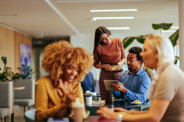 Joyful coworkers socializing at lunch.