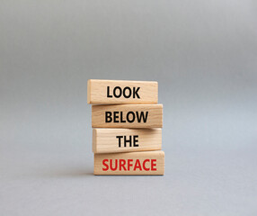 Look below the surface symbol. Concept word Look below the surface on wooden blocks. Beautiful grey background. Business and Look below the surface concept. Copy space
