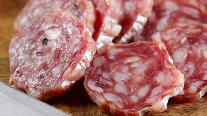 saucisson sec tranché en gros plan sur une table en bois