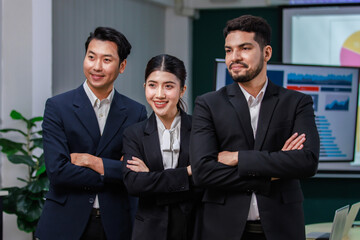 Fototapeta premium Millennial Asian professional successful female businesswomen Indian multinational male businessmen in formal business suit standing side by side crossed arms posing taking photo together in company