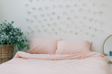 pink bedding with pillows and flower wall