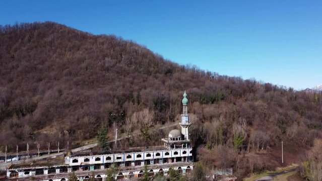 Aerial view over Consonno a 'ghost town' of Olginate, Lecco, in Lombardy, vegetation and snow-capped mountains in the background.