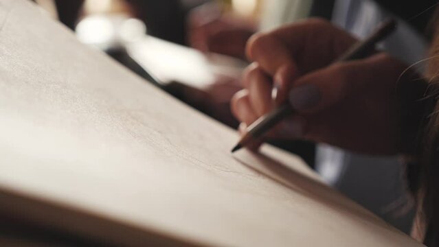 The artist draws a sketch on a piece of paper