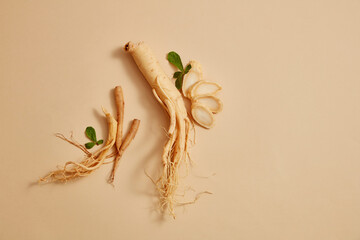 Korean ginseng root and some ginseng slices decorated on beige background. Blank space for text or product adding - obrazy, fototapety, plakaty