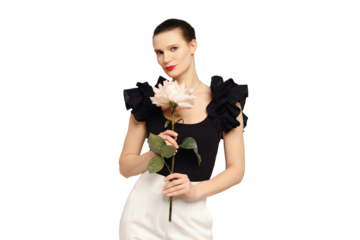 Stylish and positive adult woman posing in studio with rose in hands