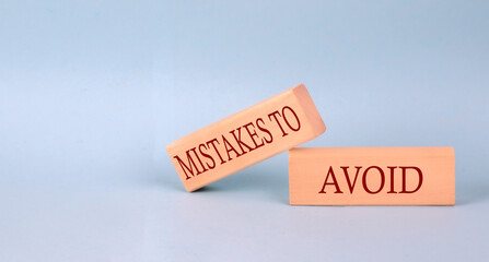 MISTAKES TO AVOID text on the wooden block, blue background