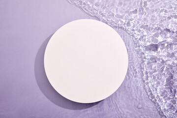 Minimal art background with round empty podium on blue water background. Copy space for cosmetics, business branding and product presentation. Top view, flat lay.