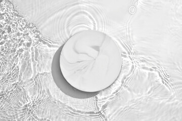White circle podium on transparent clear water texture with splashes and waves in sunlight. Blank...