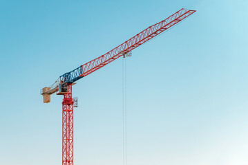 Construction crane in front of cloudless sunny blue sky