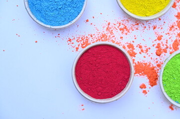top view of colorful traditional holi powder in bowls isolated on dark background.Space for text . happy holi.Concept Indian color festival called Holi