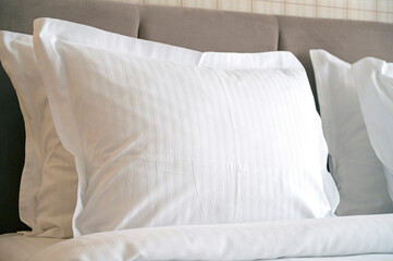 Close-up of white pillows on a bed in Hotel, white clean pillow in comfortable room