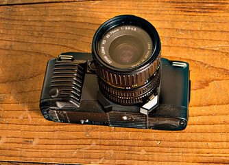 Old reflex camera on wooden background