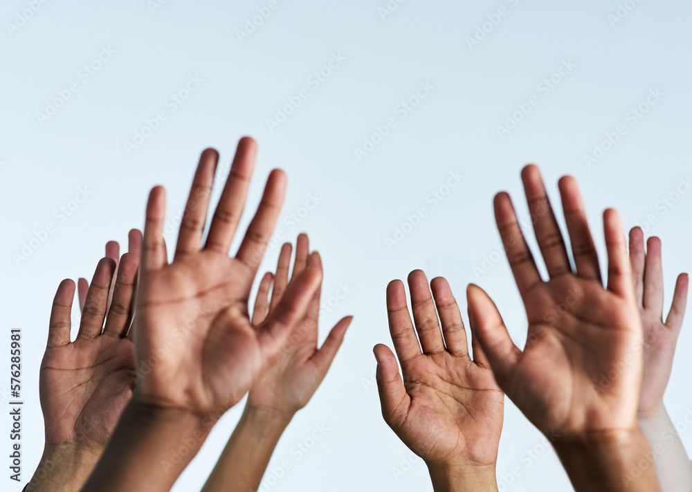 Poster raise your hands in support of each other. shot of a group of hands reaching up against a white back